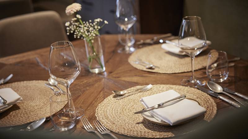 Gedeckter Tisch mit Riedel Weingläser und Blumenschmuck