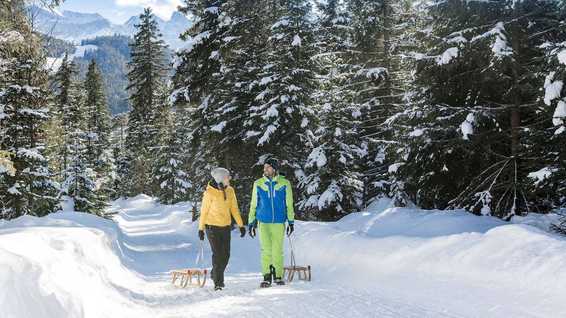 Paar ziehen Schlitten in Winterlandschaft hinter sich her
