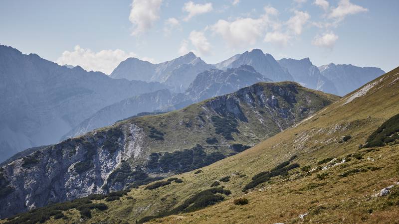 Der Naturpark Karwendel mit Wiesenhang und dahinter die schroffen Berge 