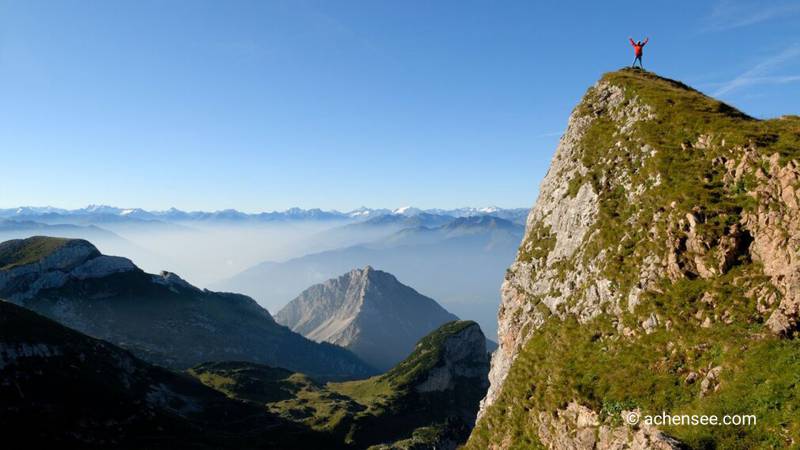 Wanderer steht am Hochiss traumhafter Ausblick auf die Bergwelt des Rofan Gebirges