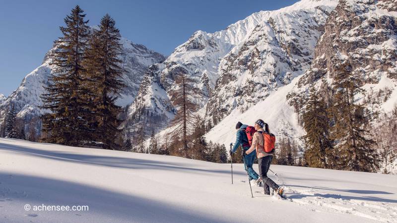 Zwei Schneeschuhwanderer machen Spuren im Tiefschnee bei schönster Winterlandschaft