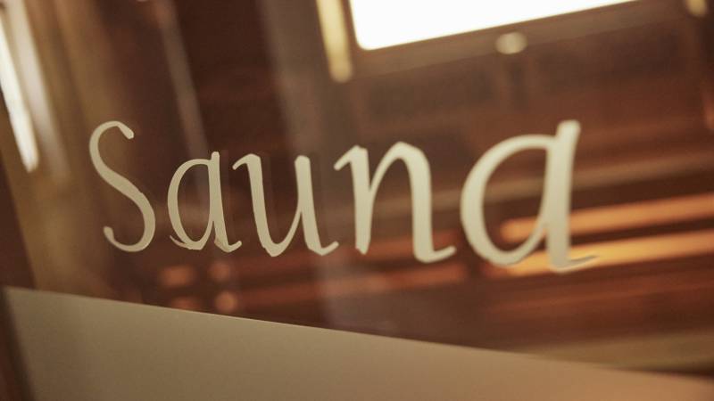 Nahaufnahme Schriftzug Sauna auf Glastür